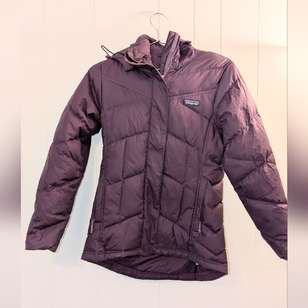 Patagonia women’s insulated down jacket in a rich plum purple color.